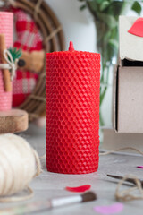 Red wax candle on the table. flowers in the vase. 