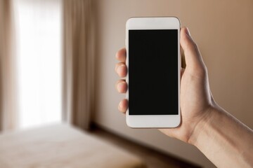 Human using smartphone, controlling smart home systems in modern apartment, blank screen