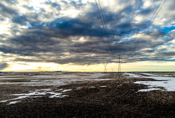 Power lines and transmission towers on the Alberta prairies under a dramatic sky in Rocky View County Canada