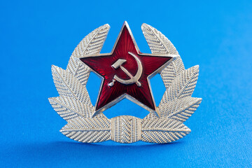 Soviet Russian military insignia cockade for a headdress cap isolated on a blue background close-up