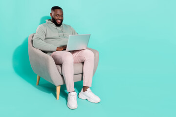 Full length body size view of handsome trendy focused guy using laptop working remotely isolated...