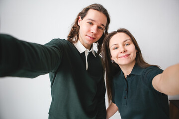 a couple man and woman hugging and taking a photo on the phone. Couple taking selfie on white background
