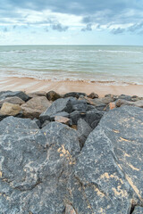 Landscape of a path of rocks in front of the beach, sand strip the beautiful sea of the brazilian northeast coast. Boa Viagem beach in Recife city, PE, Brazil.
