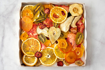 various multi-colored dry fruits in a kraft box, top view