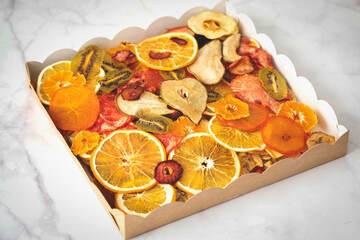 various multi-colored dry fruits in a kraft box, top view