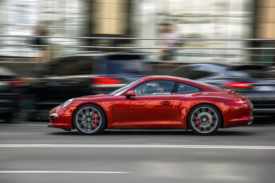 Kiev, Ukraine - June 19, 2021: Red supercar Porsche 911 in motion. High speed. Porsche in the city