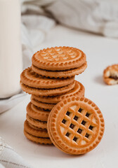 Fototapeta na wymiar Stack of crispy cookies close up with chocolate filling on a white table.