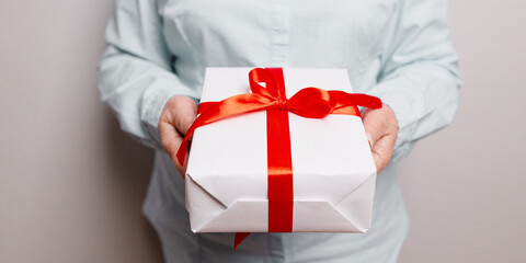 Businessman in shirt hands holding a beautiful gift box, female gift, christmas holidays and greeting season concept