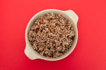boiled buckwheat in small white bowl on red