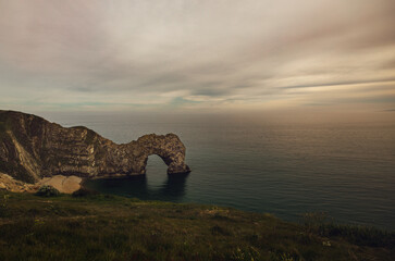 Fototapeta na wymiar A natural arch into the sea at Durdle Door, Dorset, UK. Sunset at the beach.