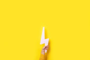 lightning bolt icon in hand over yellow background, layout image