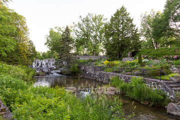 Fototapeta na wymiar View of the Du Berger River and small waterfall in the Des Moulins Park seen during a spring early morning, Quebec City, Quebec, Canada