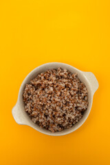 boiled buckwheat in small white bowl on yellow