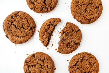 Chocolate chip cookies on a white background. Delicious homemade chocolate chip cookies beautifully laid out on a white background. Cracked cookies and crumbs. Great breakfast with coffee or milk