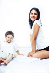 cute little boy in bed with mother in pajamas having fun happy smiling, lifestyle people concept