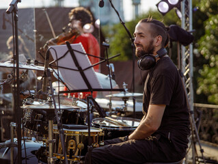 Cheerful male drummer having rehearsal on the street