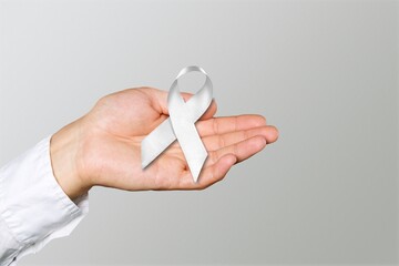 White January, mental health awareness campaign. hand hold a white ribbon. - obrazy, fototapety, plakaty