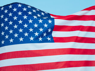 Close-up of the American flag hanging against a clear blue sky.