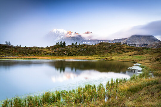 Mist on Fletschhorn and Galehorn mountains reflected in Hopschusee lake at dawn, Simplon Pass, Valais Canton, Swiss Alps, Switzerland