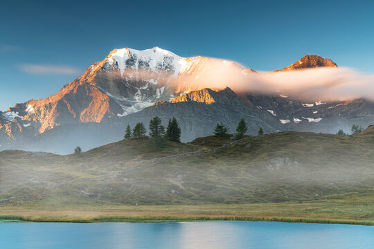 Majestic Fletschhorn and Galehorn peaks in autumn fog at dawn from Hopschusee lake, Simplon Pass, Valais Canton, Swiss Alps, Switzerland