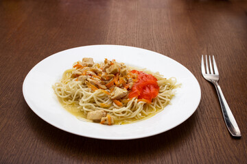 spaghetti with meat and vegetables on a white plate