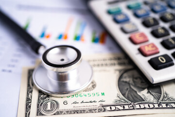 Stethoscope with US dollar banknotes on chart graph paper, finance, account, statistic, analytic...
