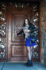 Obraz premium young girl stands near an old wooden door