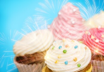 Assortment of brightly colored celebration cupcakes decorated with sparklers for a birthday party concept