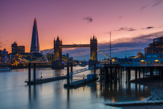 Tower Bridge and The Shard at sunset with a low tide on the River Thames, London, England