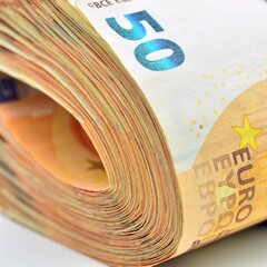 Detalle de un paquete de dinero. Billetes de 50 euros doblados y apretados con banda, aislado en...
