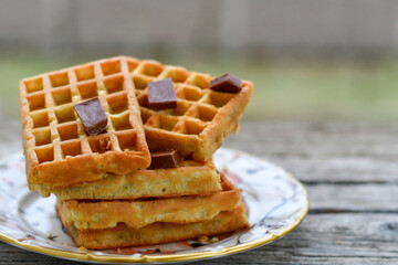 Traditional Belgian waffles with chocolate on a plate on wooden background