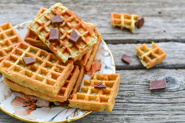 Traditional Belgian waffles with chocolate on a plate on wooden background