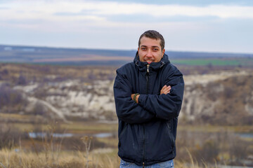 man or an adult guy a tourist or a hiker in a windbreaker is freezing from the cold. Background with copy space © Iurii Gagarin