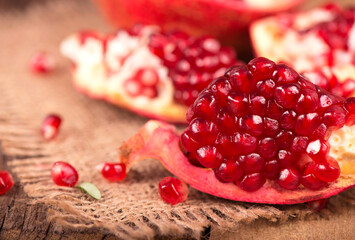 Juicy pomegranate and its half Beautiful composition with juicy pomegranates, on old wooden table