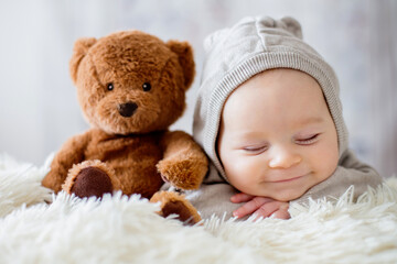 Sweet baby boy in bear overall, sleeping in bed with teddy bear - Powered by Adobe