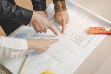 Builder team, asian young engineer man, male and architect woman are discussing construction on blueprint to follow the project to build an industrial plan at site. Engineer worker people concept.