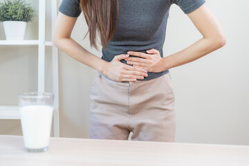 Pain, Allergy asian young woman, girl hand in belly suffer after drink glass of milk, unhappy and bad stomach ache. Lactose intolerance and dairy food , health problem concept.