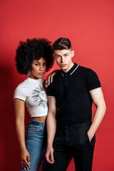 Multiracial couple studio shooting over a red background