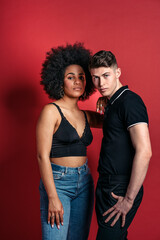 Multiracial couple studio shooting over a red background