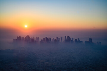 Doha skyline at sunrise with morning fog