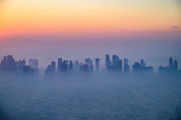 Doha skyline at sunrise with morning fog