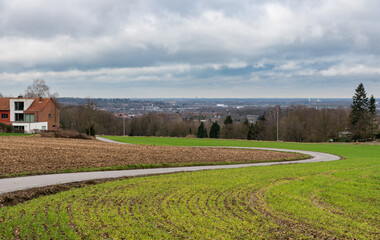 Leuven, Flemish Brabant Region, Belgium - 01 29 2022: Soft road through the cultivated farmland