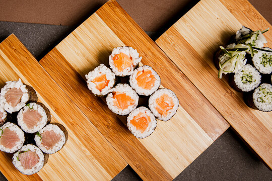 Japanese food: maki and nigiri sushi set on wooden background. Flat lay top-down composition. Copyspace