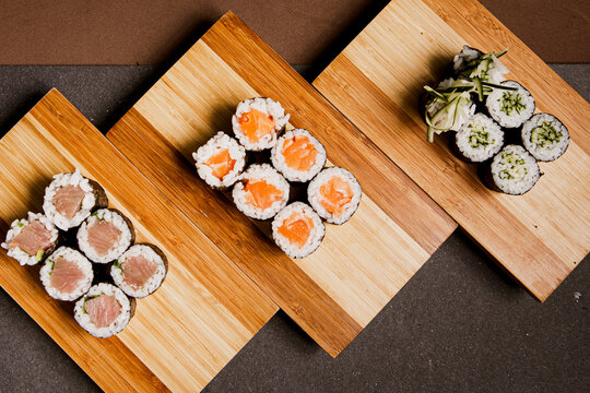 Japanese food: maki and nigiri sushi set on wooden background. Flat lay top-down composition. Copyspace