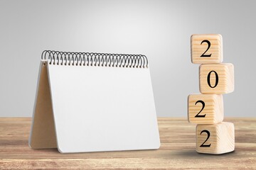 2022 mockup notepad and cubes wooden on table background, plans for New Year 2022