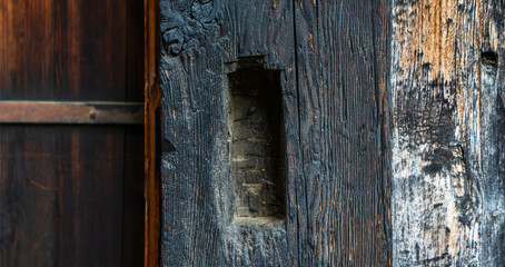 Old dark color wood wall for seamless wood background and texture. Rustic weathered barn wood background with knots and nails.