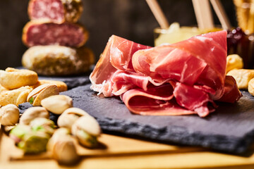 Wooden cutting board with cold cuts and cheeses