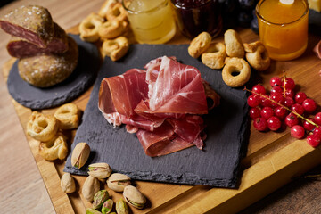 Wooden cutting board with cold cuts and cheeses