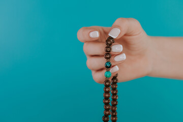 Woman lit hand counts mala beads strands of gemstones used for keeping count during mantra...