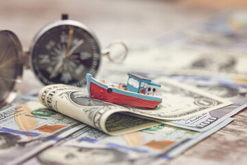 A small toy boat overcomes waves of dollar bills